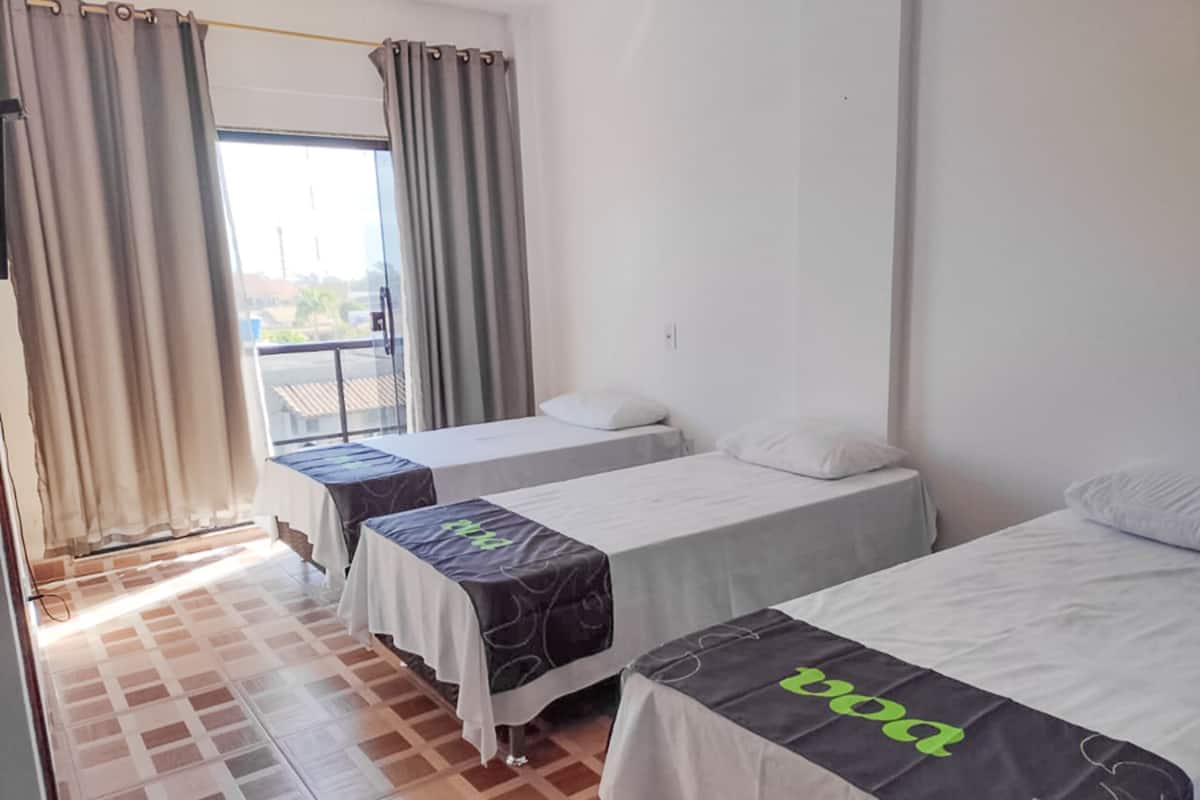 Ein Hotelzimmer mit zwei Betten, einem Balkon und Blick ins Freie.