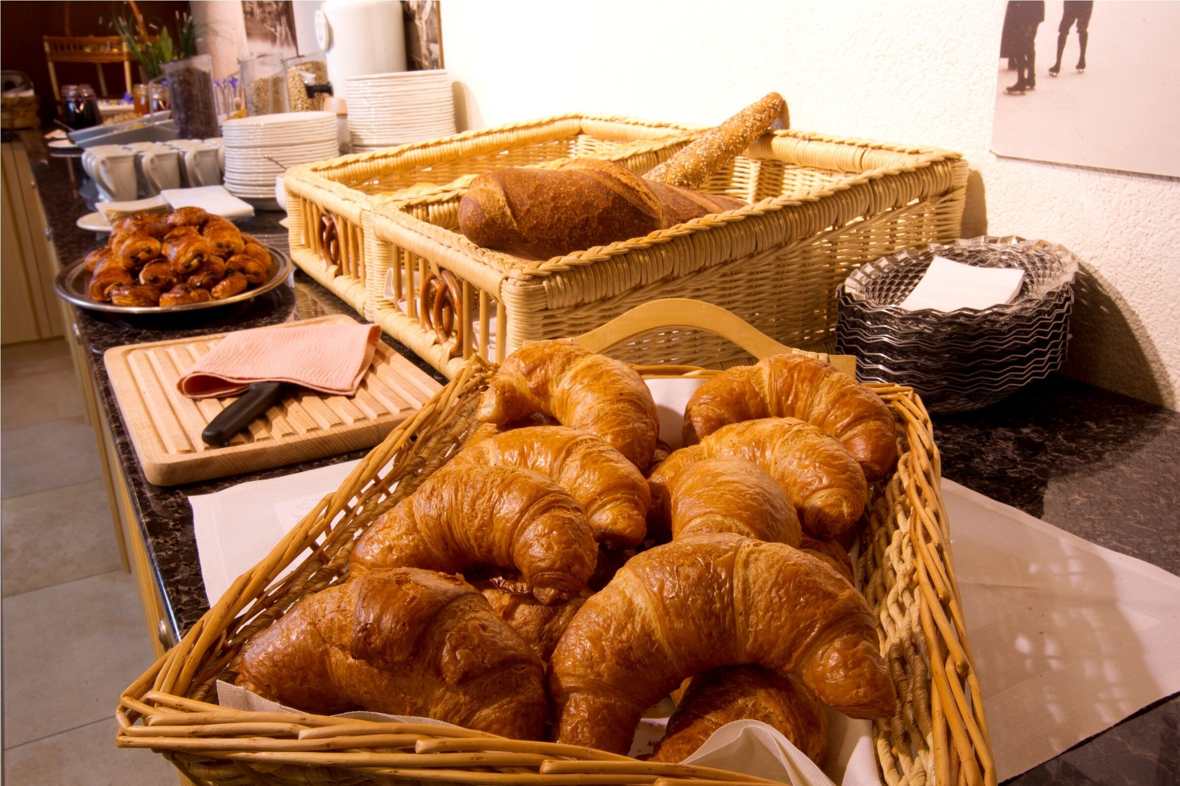 Un bufé de desayuno con cruasanes, pan y bollería.