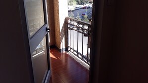 A balcony with a metal railing, a view of a parking lot, and a building in the background. - Bruhway Hotel (Addis Ababa)
