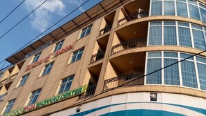 A hotel with a curved facade, balconies, and a visible shop named "SHOA SHOPPING CENTER" on the ground floor. - Bruhway Hotel (Addis Ababa)