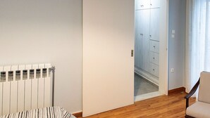 A room with a radiator, a door leading to a hallway, and a chair. - Classy & Spacious Flat near Marina of Patra (Patras)