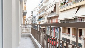 A residential building with balconies, a narrow street, and parked cars. - Classy & Spacious Flat near Marina of Patra (Patras)