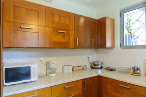 Eine Küche mit Holzschränken, einer Mikrowelle, einer Kaffeemaschine und einem Toaster.