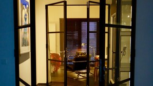 Een kamer met een deur van glas, een betegelde vloer en een bureau met een stoel.