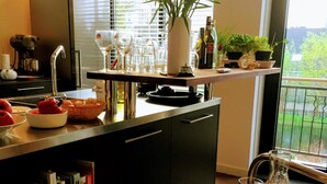 Een helder verlichte keuken met een eethoek, met een tafel gedekt met borden, glazen en diverse etenswaren.