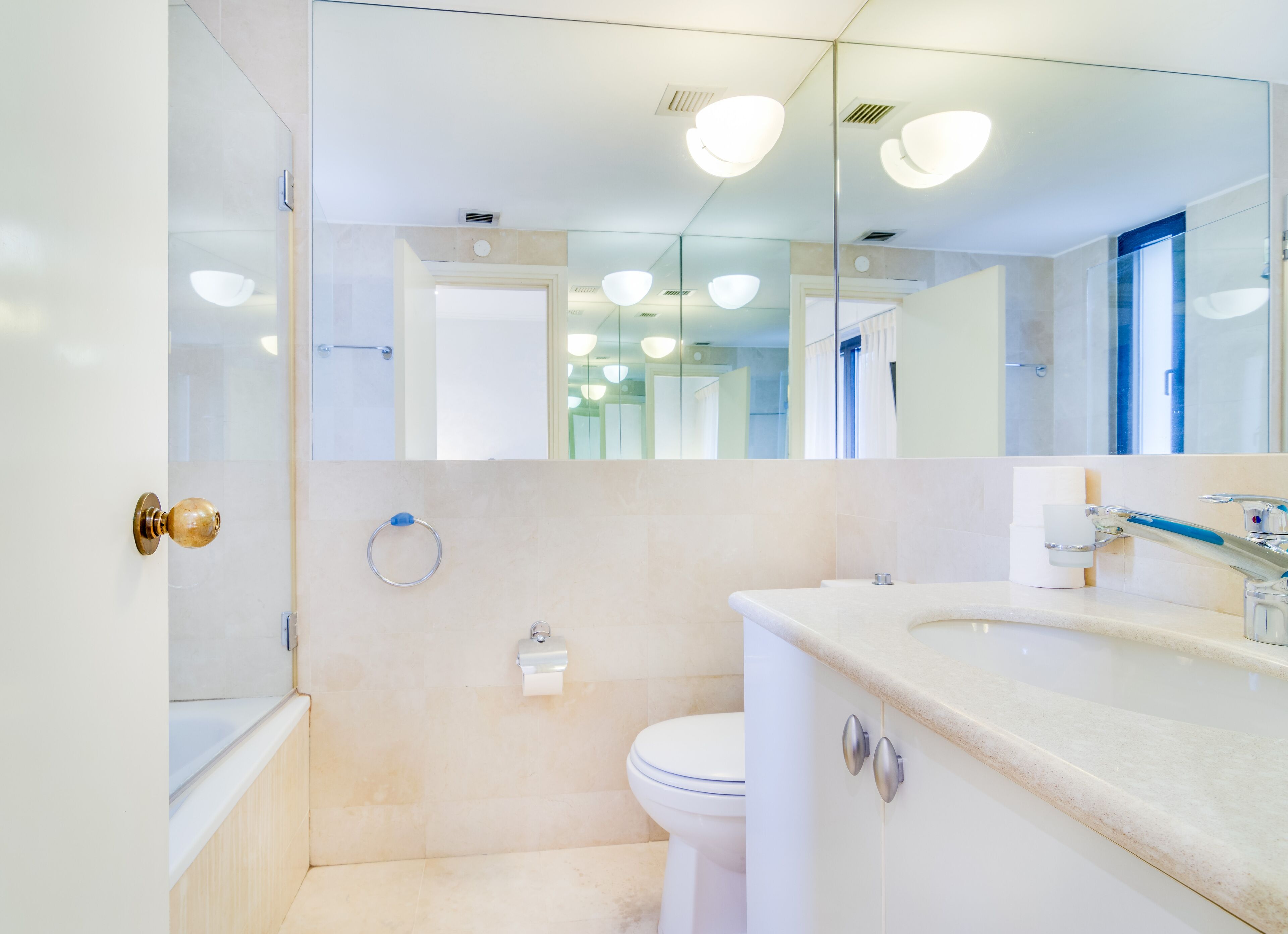 Une salle de bain moderne équipée de toilettes, d’un lavabo et d’une douche à parois en verre.