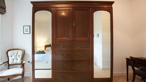 A large wooden wardrobe with mirrored doors and multiple drawers. - Apartment 4 The Grove (Durham)