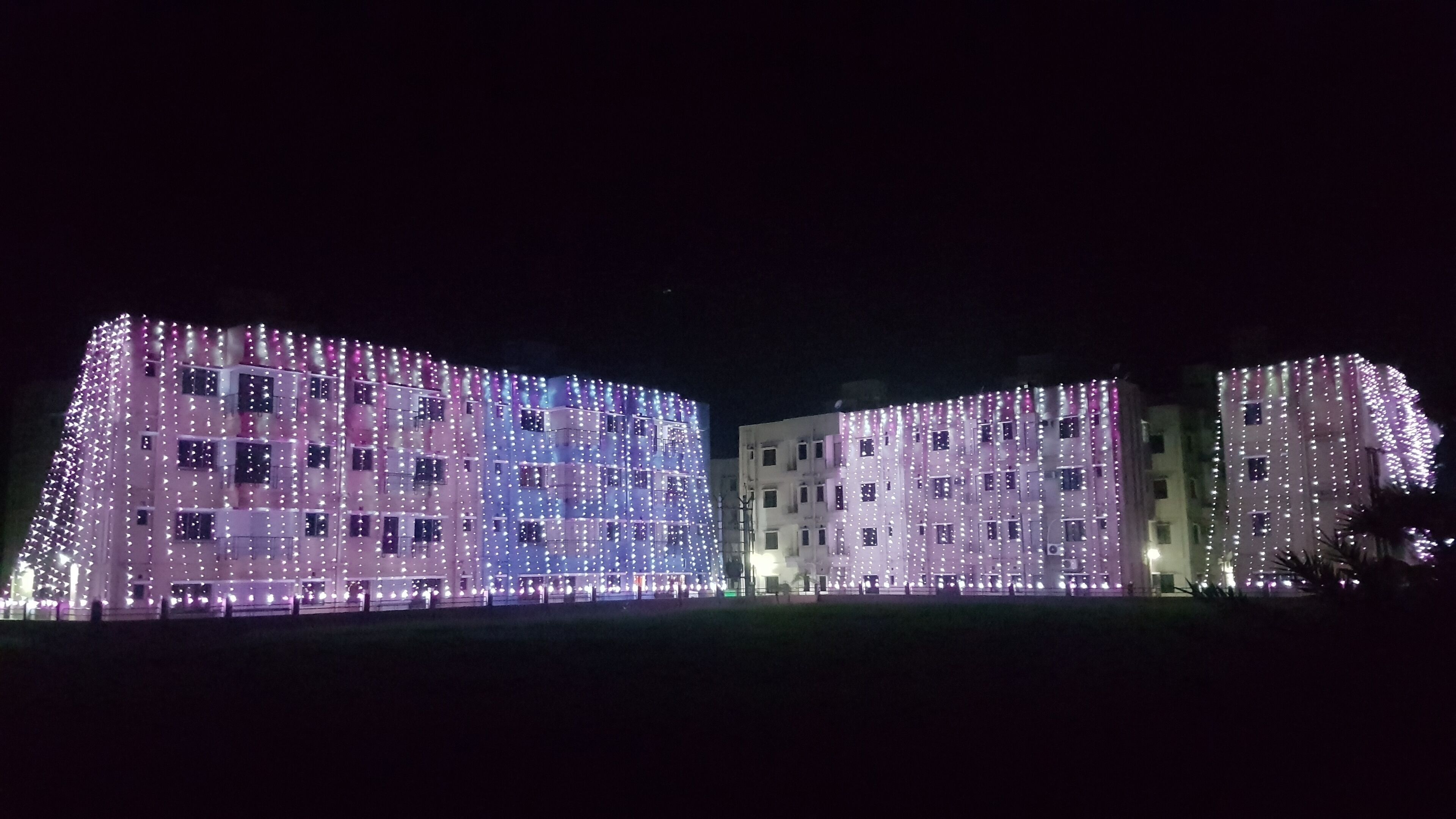 A building with multiple floors, each adorned with numerous lights.