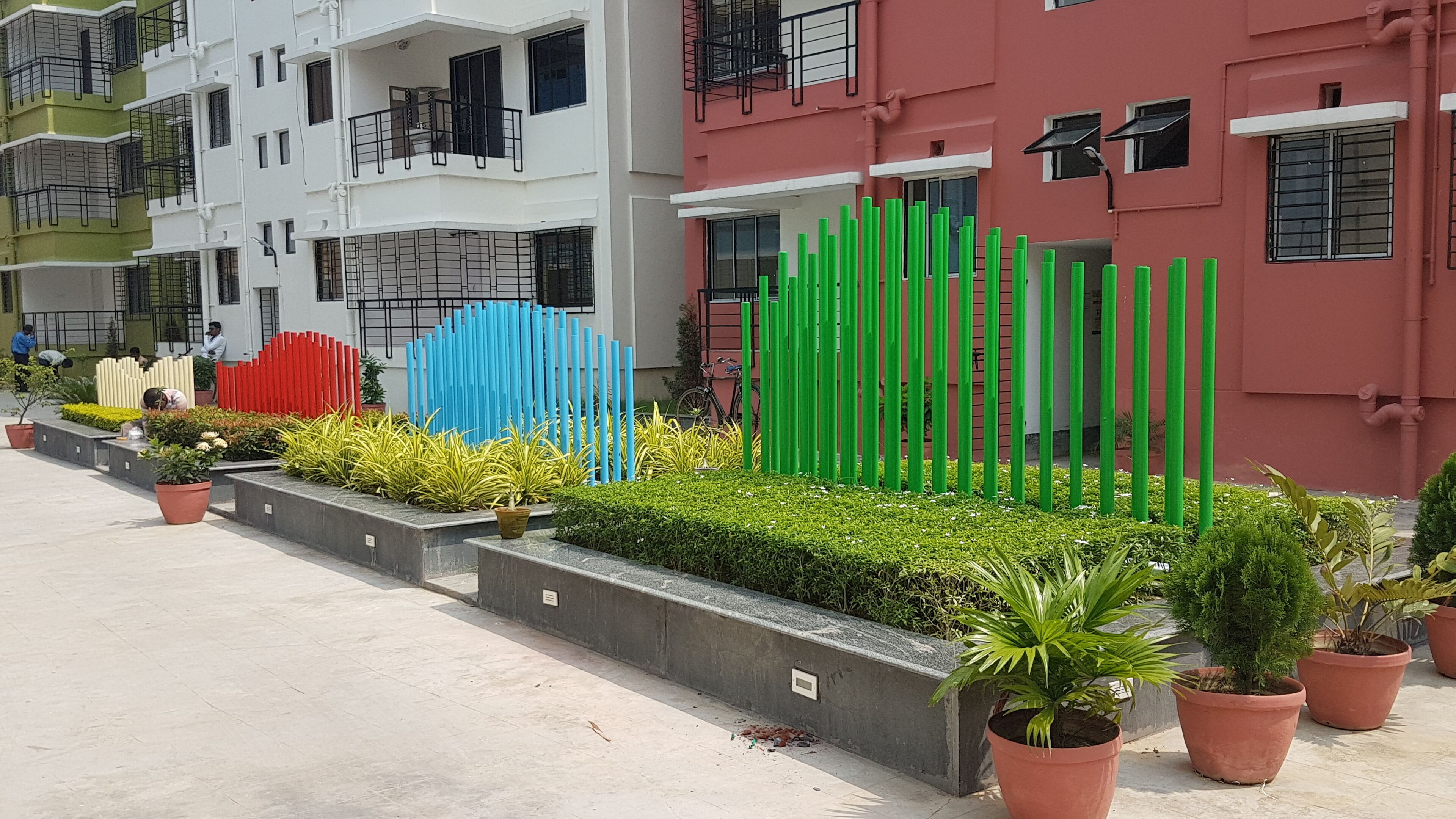 Una hilera de vallas coloridas frente a una fila de edificios de varios pisos.