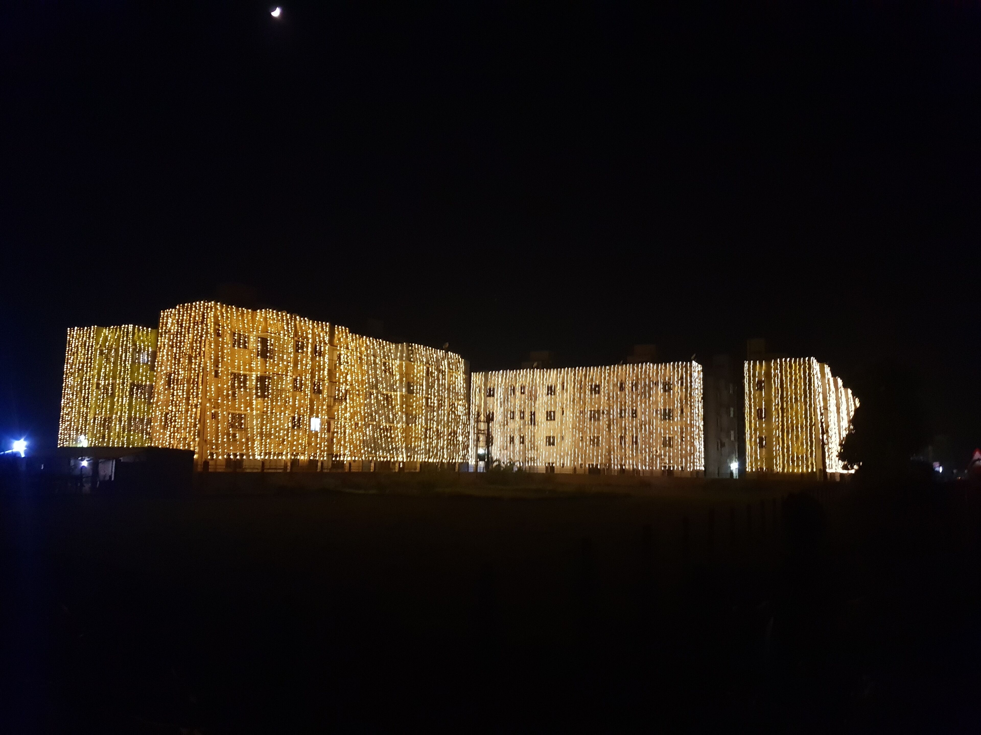 A building with a facade covered in numerous lights, creating a uniform pattern.