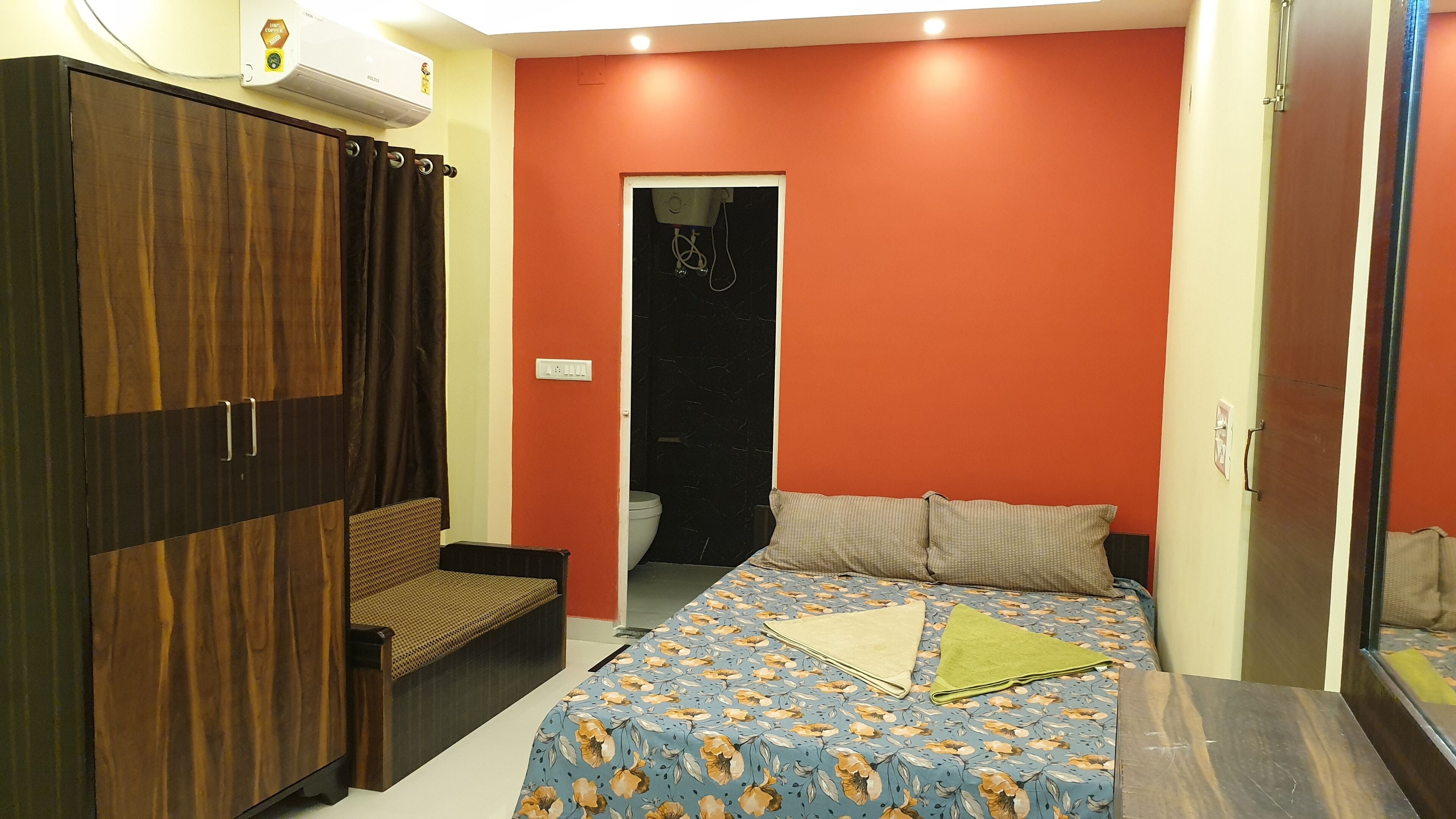A bedroom with a bed, a wardrobe, and a bathroom door.
