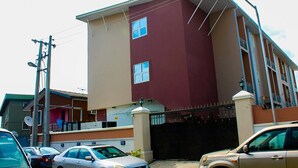 A multi-story building with a flat roof and a gated entrance. - Kelin Court Hotel (Lagos)