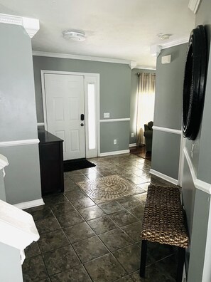 Enter a serene hallway with a door, bench, and coat rack.