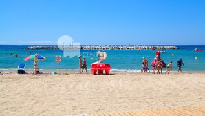 A beach with a lifeguard tower, beach chairs, and umbrellas. - Spacious villa with private pool and free wifi, sleeps 12 - VILLA NOSTRA (Cambrils)