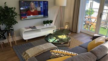 Penthouse Eksekutif | Ruang keluarga | TV layar datar dan buku
