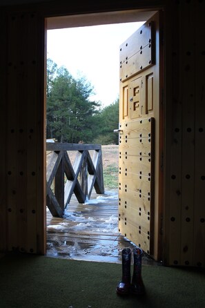 A wooden door leading to an outdoor area with a wooden bridge and a snowy ground. - Albergue Tejadillos - Hostel (Cuenca)