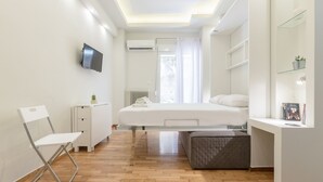 A modern bedroom with a bed, a desk, a chair, and a TV. - Cozy Flat with Terrace & Patio near Lycabettus (Athens)