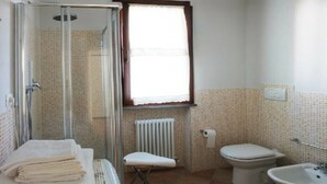 A bathroom with a glass shower enclosure, a toilet, a bidet, and a sink. - Girasole Apartment on 2 Levels - Renili House (pesaro)