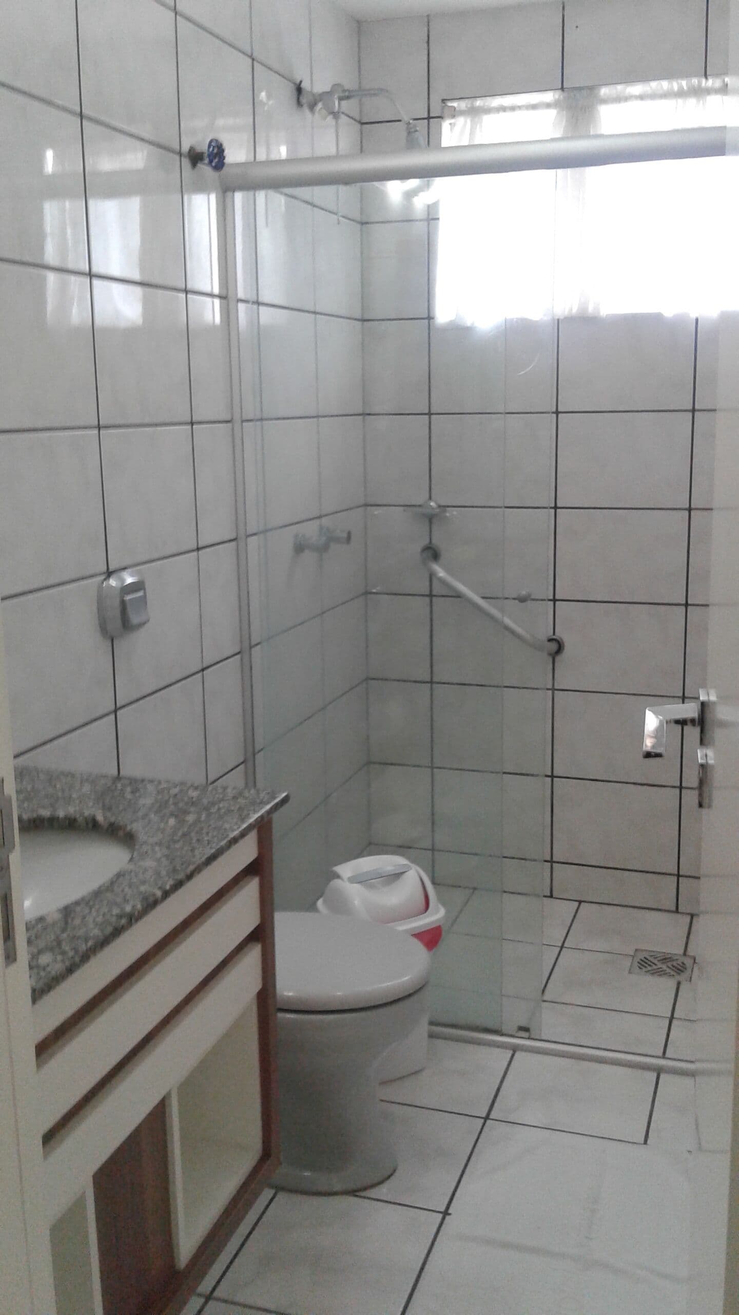 Een badkamer met toilet, wastafel en douche.