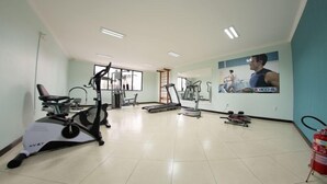 A gym with cardio machines, a treadmill, and a stationary bike.
