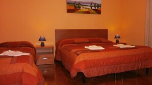 A hotel room with two beds, a nightstand, a lamp, and a painting on the wall. - Airport Pisa Rooms (Pisa)