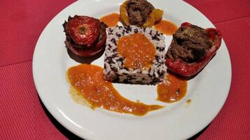 Un plato con pimientos rellenos, arroz y salsa.