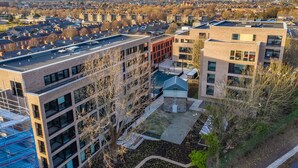 A multi-story building with a rooftop terrace, surrounded by other residential buildings. - Yugo Explore - Highfield Park (Dublin)