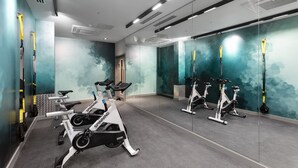 A gym with stationary bikes, a mirror wall, and a door leading to another room. - Yugo Explore - Highfield Park (Dublin)