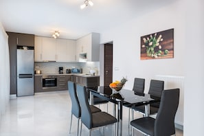 Apartamento, 2 quartos | Cozinha privada | Geladeira grande, micro-ondas, fogão, cooktop