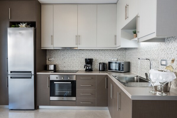 Apartamento, 2 quartos | Cozinha privada | Geladeira grande, micro-ondas, fogão, cooktop