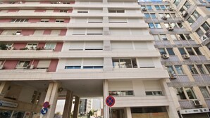 A multi-story building with a flat facade, air conditioning units, and a no parking sign. - Savory Blue Apartment, Wifi, Garage, Lift!New! (Lisboa)