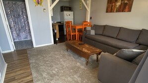 A living room with a grey sofa, wooden coffee table, and a ceiling fan. - 2 bedrooms with a shared pool. apt4 (Hampton)
