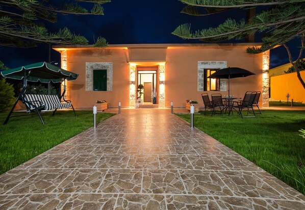 Vista frontal de la propiedad por la tarde o noche