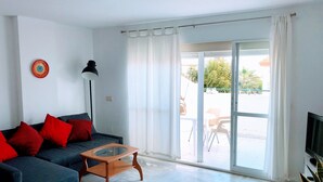 Een moderne woonkamer met een bank, een bijzettafeltje en een televisie.