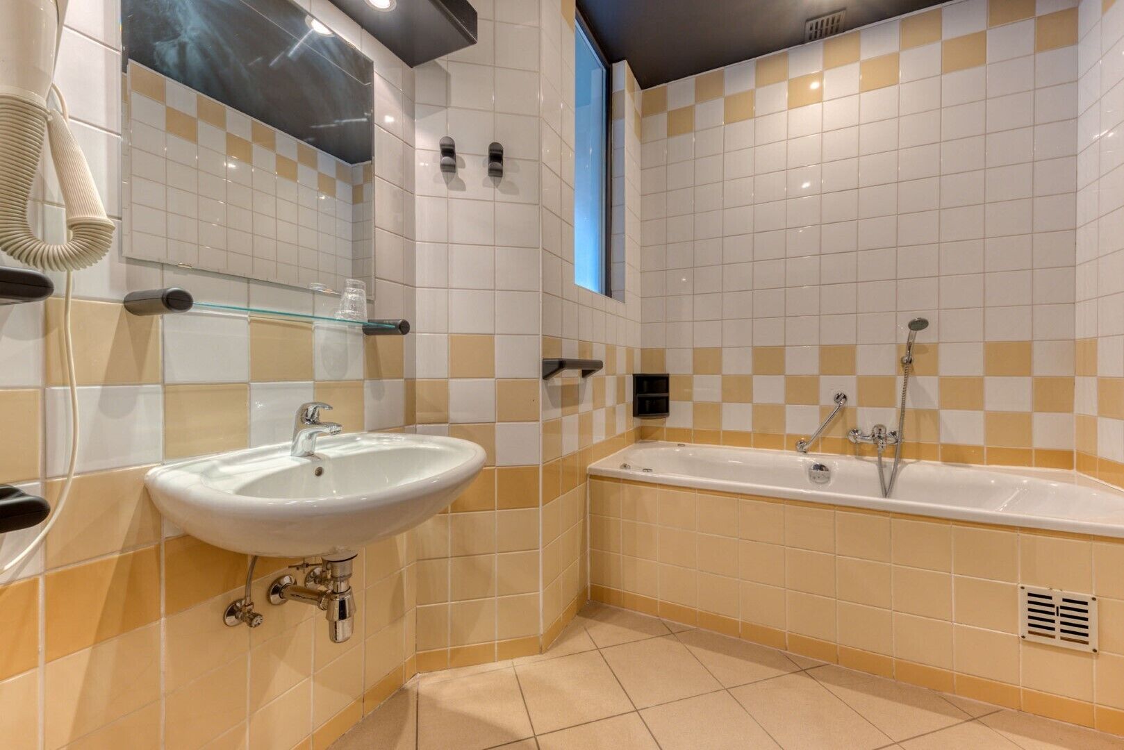 A bathroom with a sink, a bathtub, and a window.