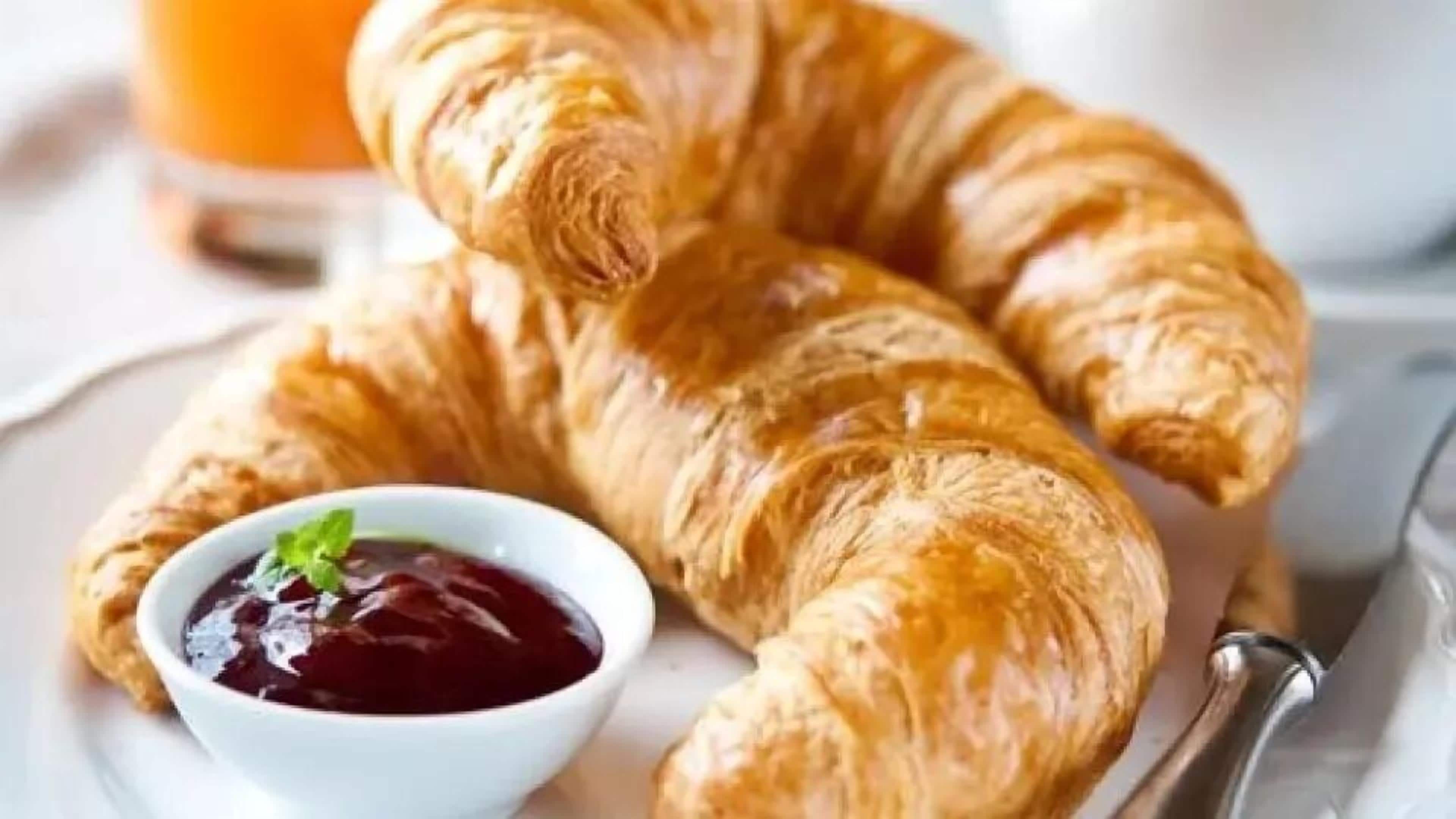 Twee croissantjes en een klein schaaltje jam.
