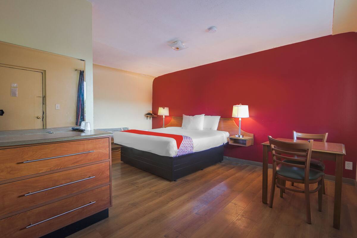 Une chambre d’hôtel comprenant un lit, des tables de chevet, un bureau et une chaise.