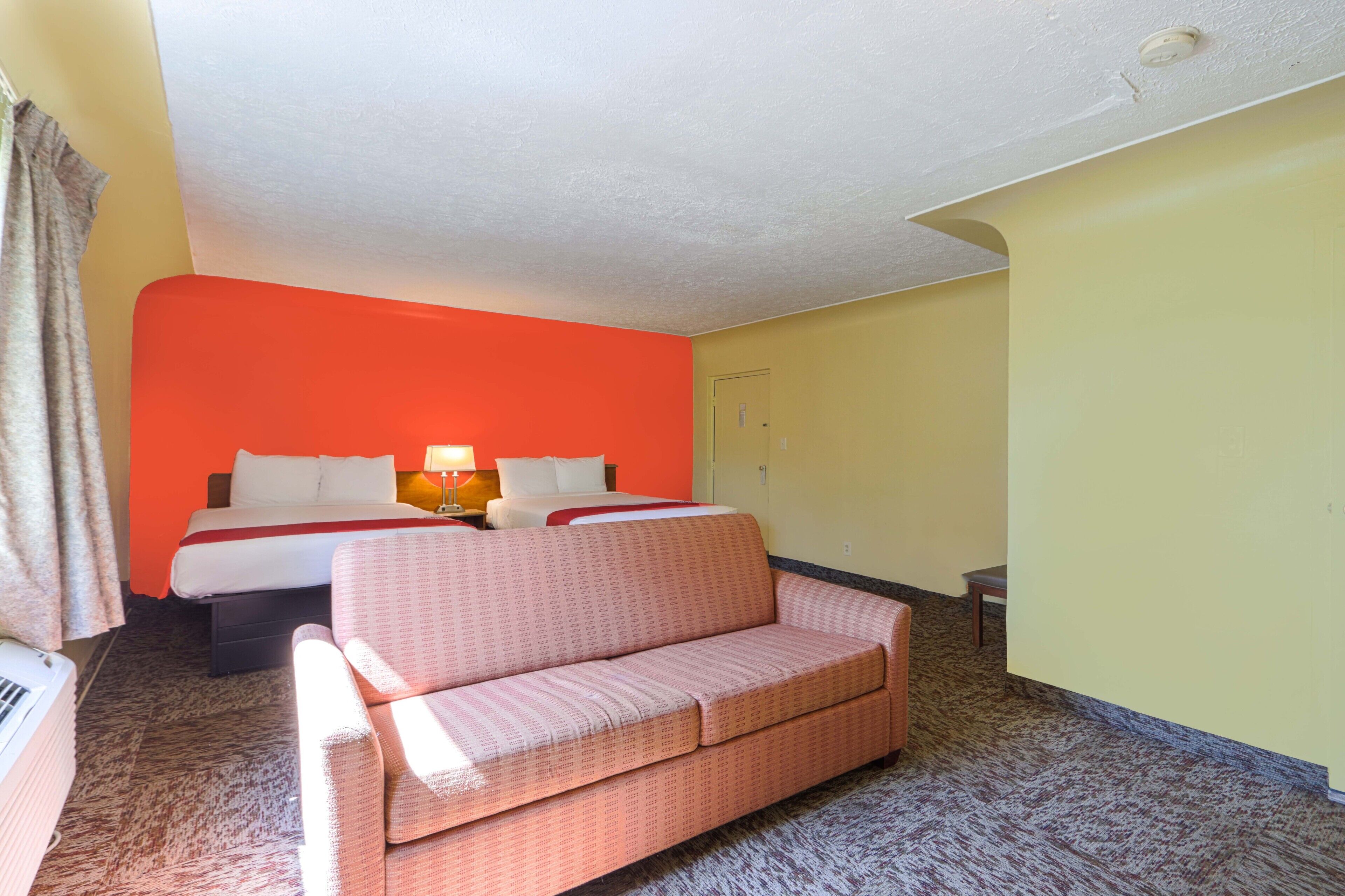 Habitación de hotel con cama, sofá y una mesita.