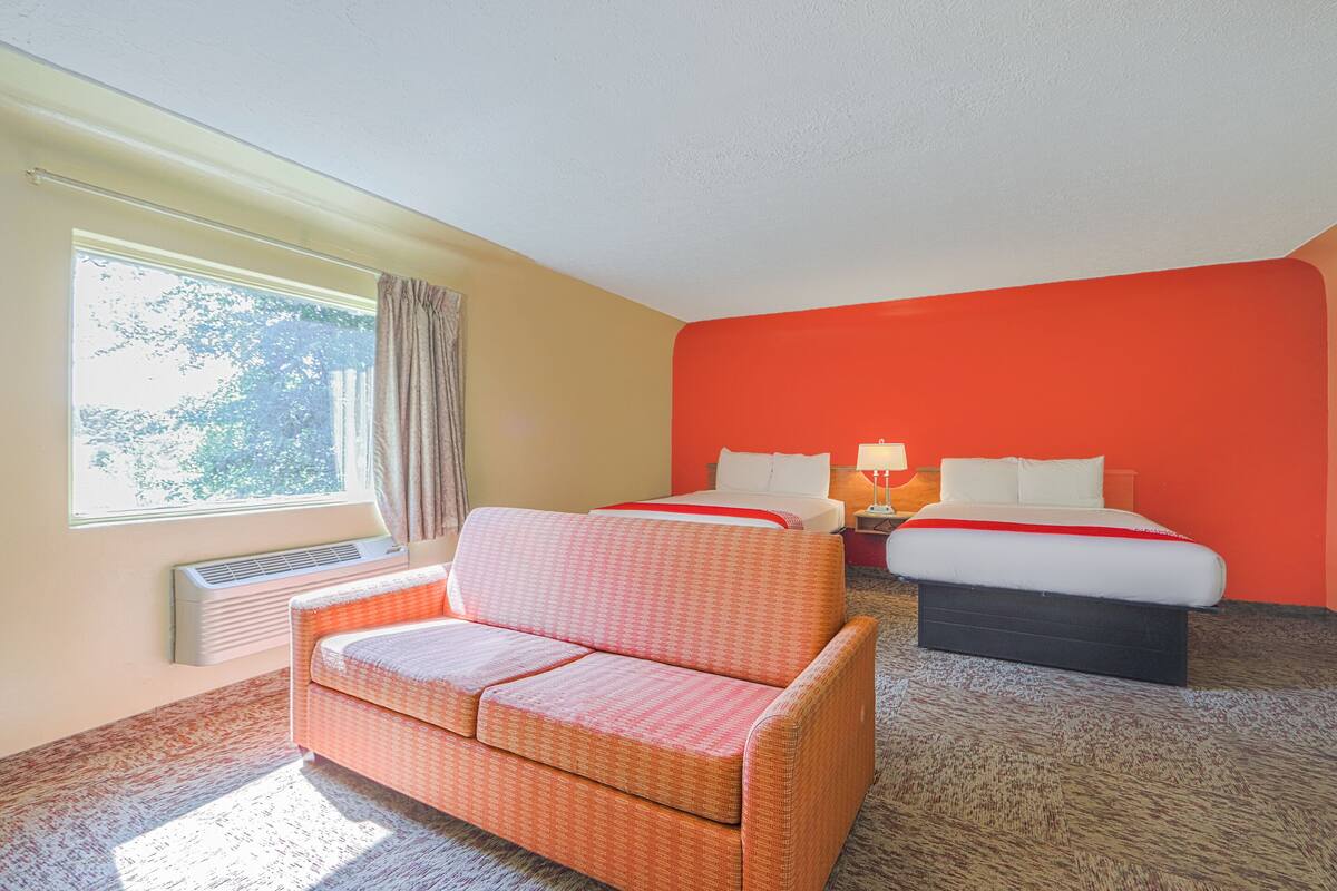 Une chambre d’hôtel avec un canapé, un lit et une table de chevet.
