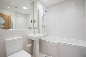 Ein modernes Badezimmer mit Toilette, Waschbecken und Badewanne.