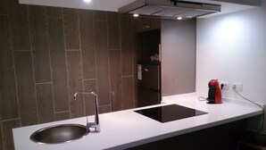 A modern kitchen with a stainless steel sink, a black induction cooktop, and a built-in oven.
