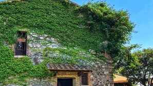 Ein Gebäude aus Stein mit rustikalem Aussehen, das einen kleinen Eingang und ein Fenster zeigt.