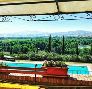 Una piscina al aire libre de temporada, sombrillas