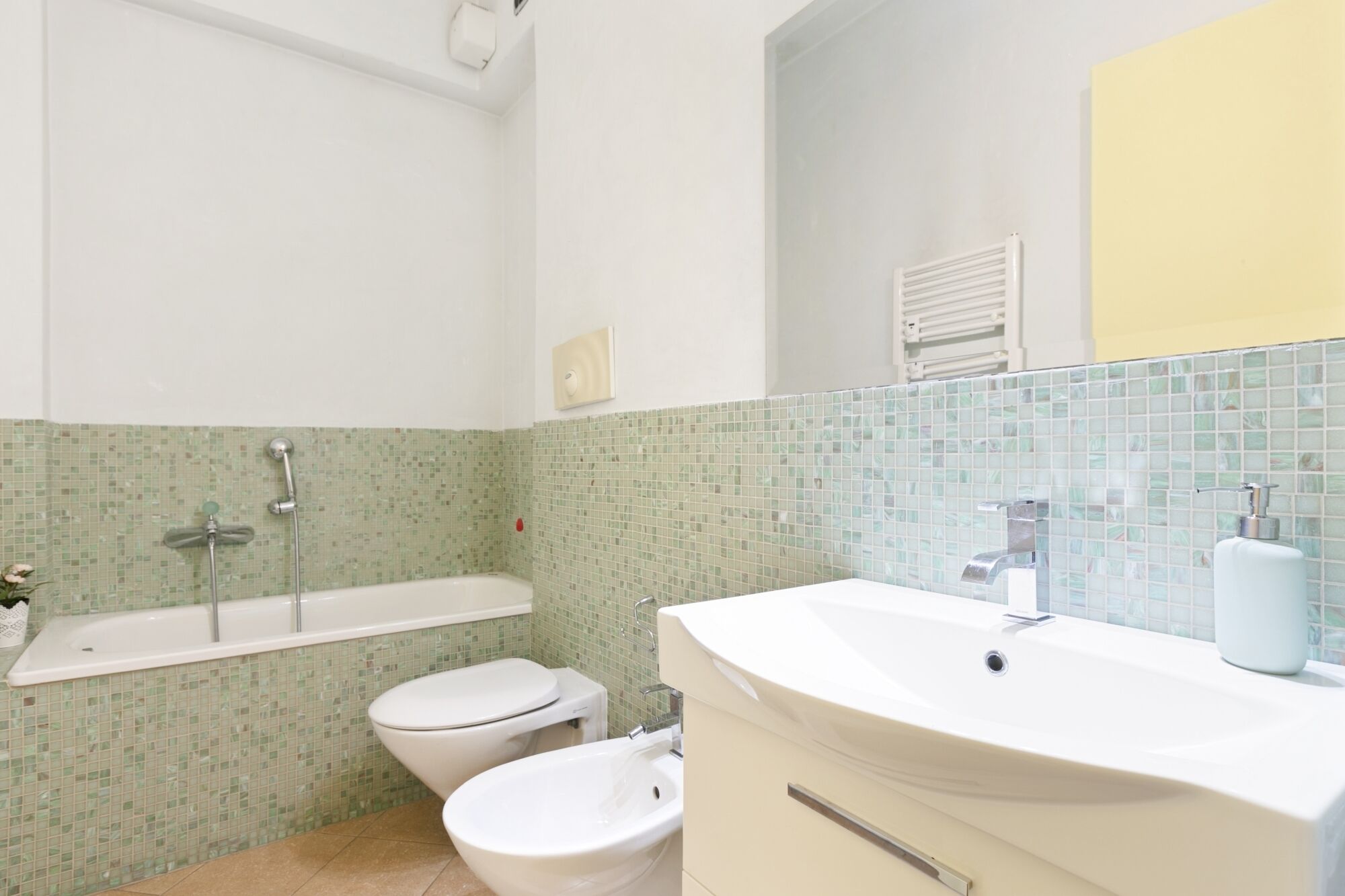 A bathroom with a bathtub, a toilet, and a sink.