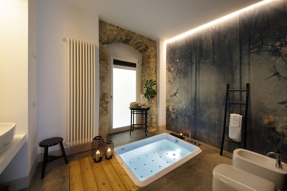 Ein modernes Badezimmer mit einer großzügigen Badewanne, einem separaten Waschbecken und einer Dusche.