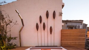 Une terrasse en bois avec un jacuzzi rectangulaire.