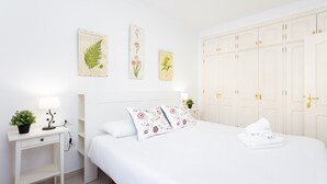 Een keurig opgemaakt slaapkamer met een bed, nachtkastjes en een kledingkast.