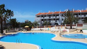 A resort pool area with a large pool, sun loungers, and umbrellas. - Luminoso apartamento con vistas al mar. wifi (Callao Salvaje)