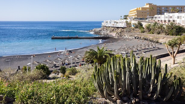 A beach with a rocky shoreline, a pier, and a building with multiple floors. - Tranquilidad, playa y vistas al mar (Callao Salvaje)