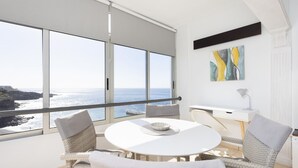 A modern room with a round table, wicker chairs, a white desk, and a large window overlooking the sea. - Tranquilidad, playa y vistas al mar (Callao Salvaje)